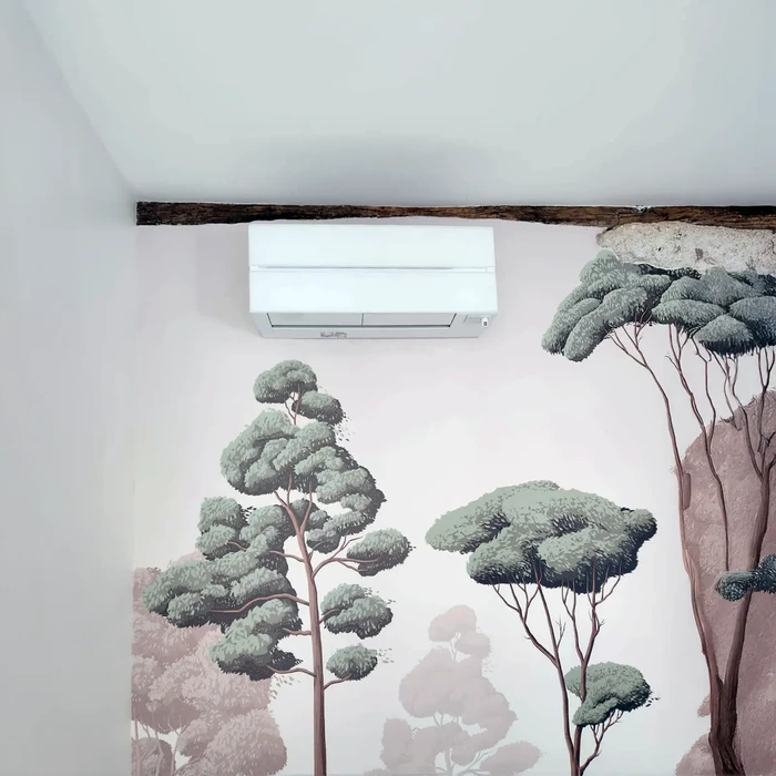 Intérieur d'une chambre avec mur peint d'arbres stylisés aux feuillages verts et troncs roses sur fond blanc