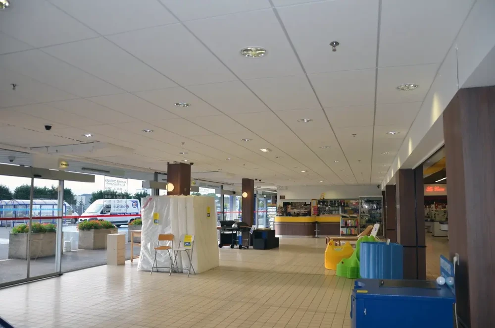 Intérieur moderne avec lustre design suspendu au plafond, diffusant motifs lumineux radiaux sur surface blanche