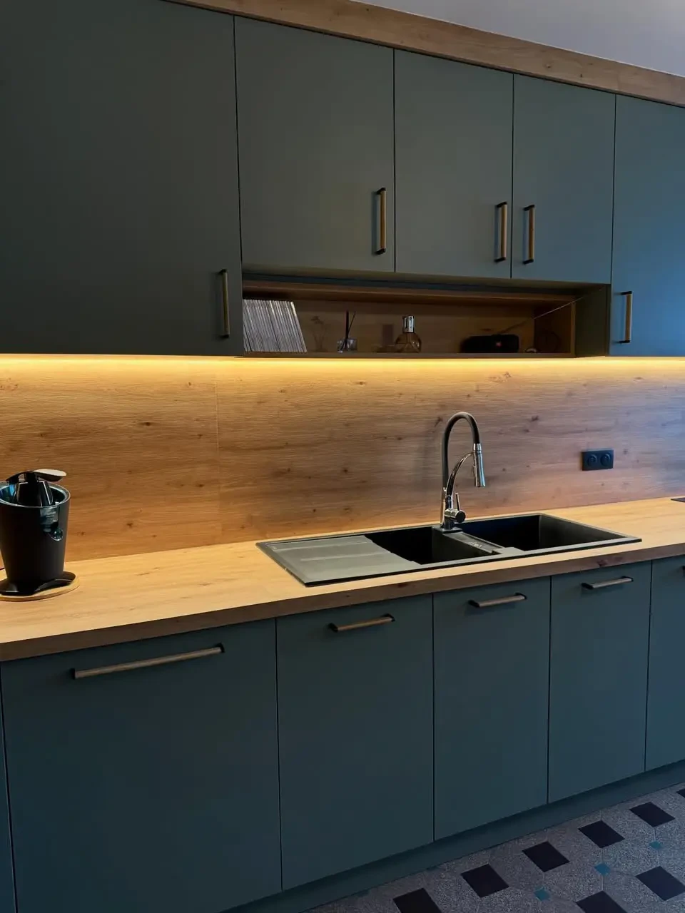 Un &eacute;lectricien en combinaison bleue travaille sur un tableau &eacute;lectrique industriel, portant un casque de s&eacute;curit&eacute; blanc